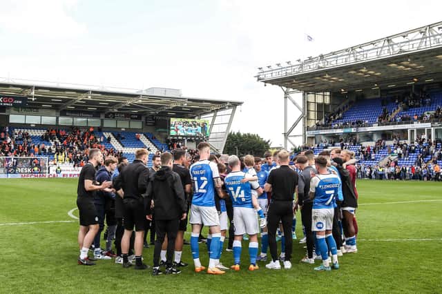 The Peterborough United players and staff huddle together at full-time after the final game of the season. Photo: Joe Dent/theposh.com.