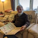 Abdul Choudhuri at home with a scrapbook of cuttings from his work in Peterborough