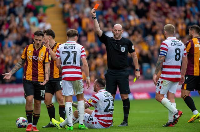 Lee Tomlin (seated) is sent off by Bobby Madden. Photo: Bruce Rollinson.