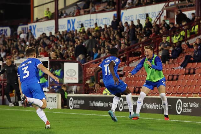 Kwame Poku of Peterborough United celebrates scoring his goal at Barnsley with substitute Josh Knight. Photo: Joe Dent/theposh.com