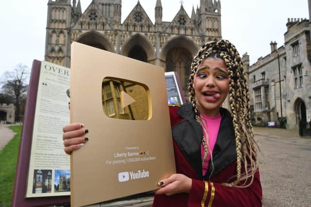 Liberty Barros with her Gold YouTube plaque for passing one million subscribers.