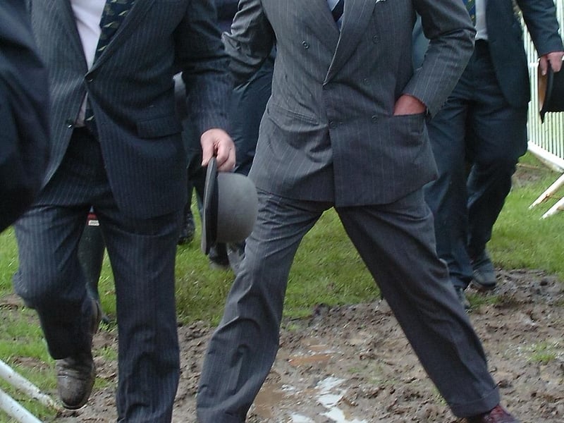 Prince Charles steps carefully through the mud during a visit to the East of England Showground in 2012
