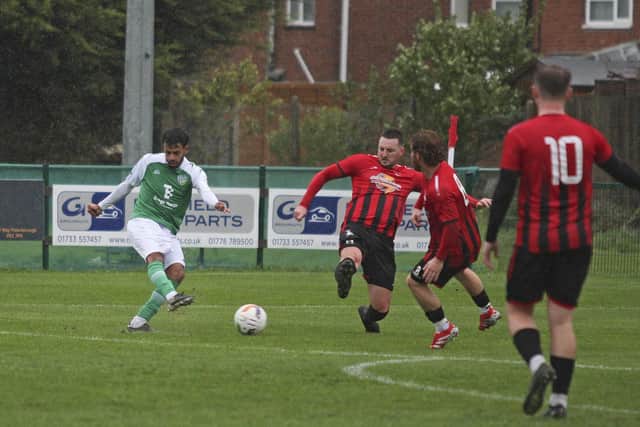 Ayman Trabelsi (green) scores for FC Peterborough Reserves against Warboys Town.