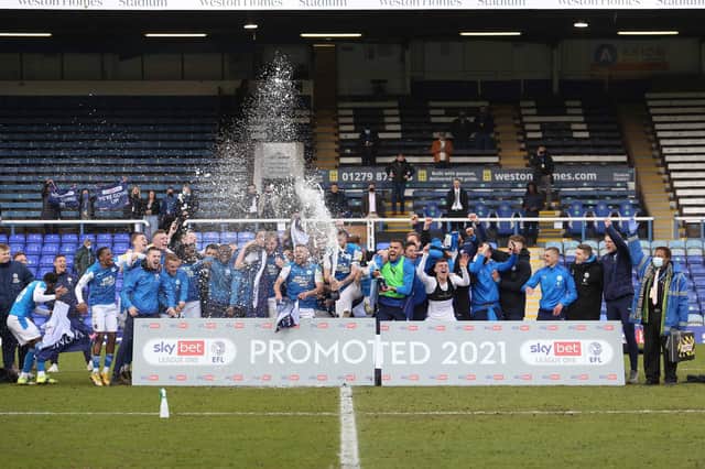 Peterborough United players celebrate promotion to the Championship.
