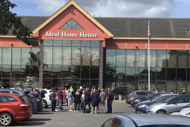 Staff gather outside the offices of Ideal World TV in Peterborough.