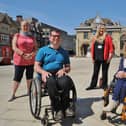 Disabled access campaigners Graham Barnes (front left) and Julie Fernandez (front right), pictured in Cathedral Square in 2021.
