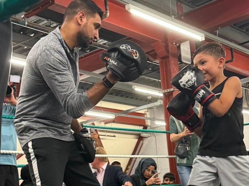 Boxing champion Amir Khan offers top tips to a young boxer at the new boxing gym in the Queensgate Shopping Centre, Peterborough