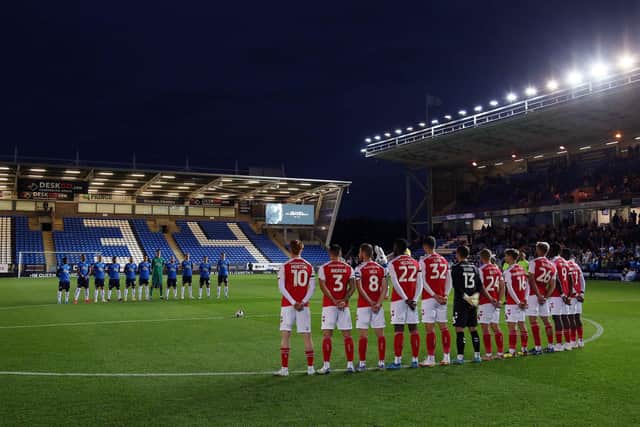 Peterborough United and Fleetwood Town players during a minute's silence in memory of the late Queen Elizabeth II. Photo: Joe Dent/theposh.com