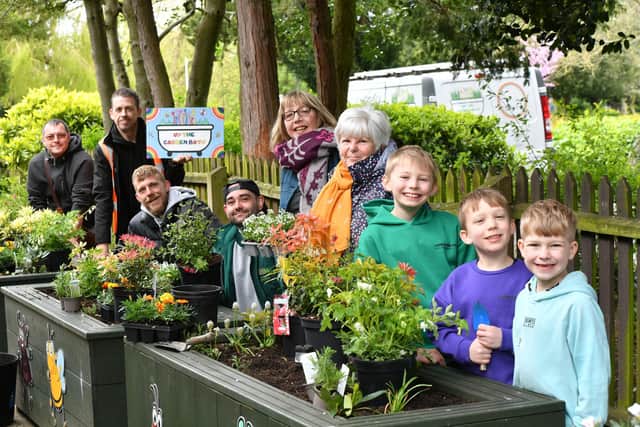 Volunteers including Mayoress Bella Saltmarsh planting flowers into Up the Garden Bath planters at Central Park.