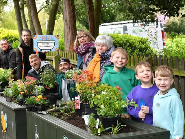 Volunteers including Mayoress Bella Saltmarsh planting flowers into Up the Garden Bath planters at Central Park.