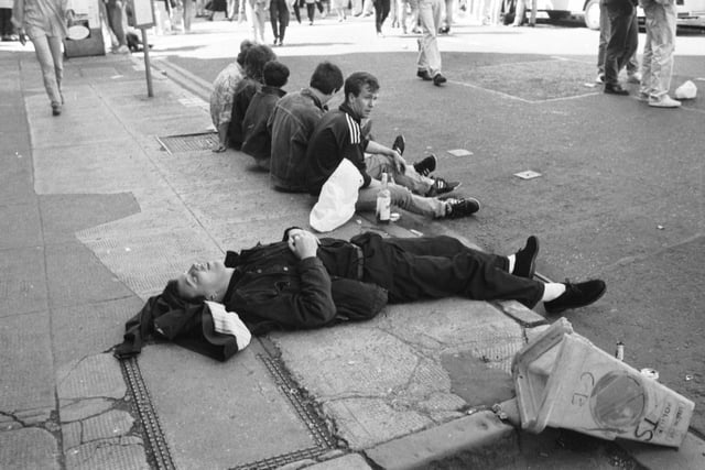 A music fan takes a nap on the pavement after the Glasgow's Big Day concert in June 1990.