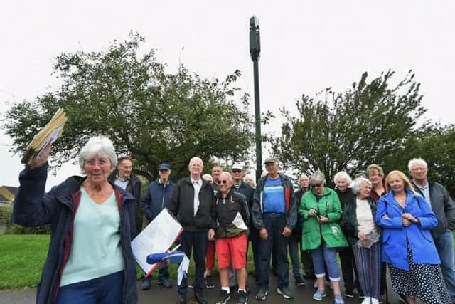 Pauline Hinchliffe holds letters of objection to future monopoles as she and other residents object more being built near their homes on Ennerdale Rise in Gunthorpe, Peterborough
