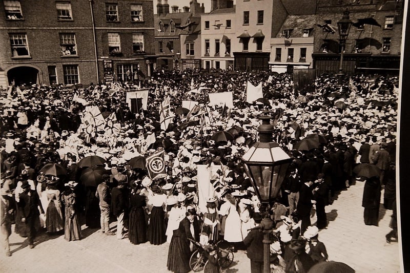 Crowds gather in Peterborough Market Place. The archive doesn't reveal the year, but it could well be the Victorian era judging by the dress.