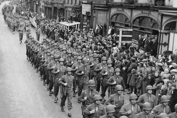 Members of the United States Air Force's Eighth 457th Bomb Group marching on Long Causeway to celebrate VE Day in May 1945. The bomb group was based at Glatton Airfield near connington from 1944-45.