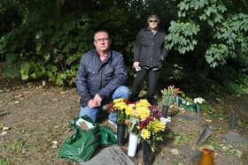 Chris Atkinson and his mother Pauline at the grave of his father at Holy Trinity Church, Orton Longueville, where items have been removed from the graves