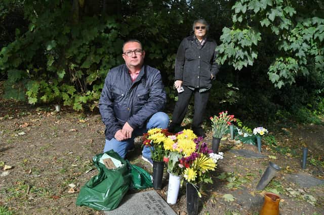 Chris Atkinson and his mother Pauline at the grave of his father at Holy Trinity Church, Orton Longueville, where items have been removed from the graves