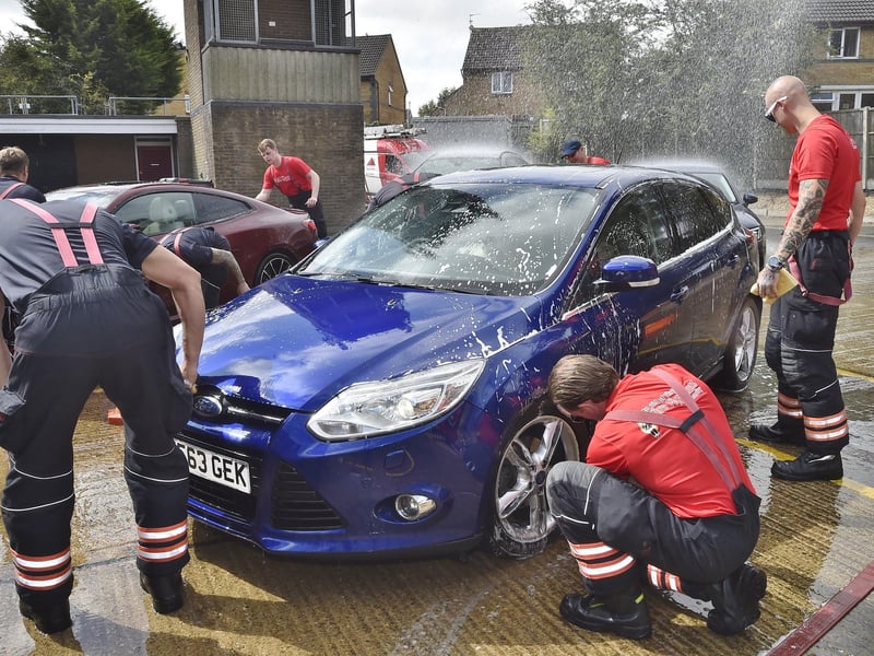 Firefighters wash cars for members of the public.