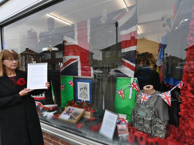 Jacqui Murphy, mother of Cpl Lee Fitzsimmons in front of the window display for which she has donated a number of Lee's possessions.