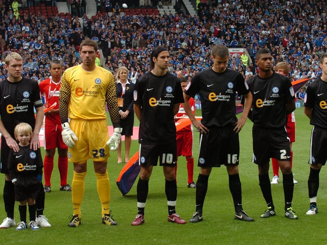 Midfield Maestro McCann scored as Posh sealed a quick return to the Championship by beating Huddersfield Town 3-0 in the League One play-off final at Old Trafford. McCann, who now manages Posh, scored in all three play-off games for Darren Ferguson's side. McCann is pictured left with son and mascot Bayley before the Huddersfield game.