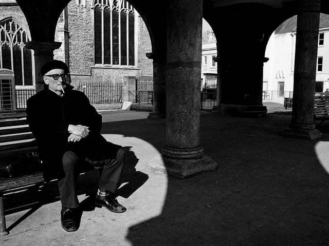 A gentleman sitting under the Guildhall and watching the world go by