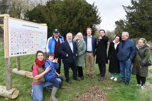 New autism communication board installed at Holywell Ponds, Longthorpe. Daniel Harris and his son with MP for Peterborough Paul Bristow and city councillors Wayne Fitzgerald, Nigel Simons, Lynne Ayres and volunteer Samia Merrington