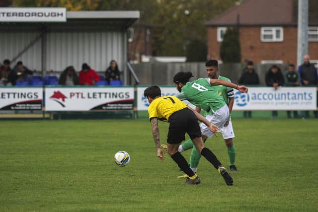 Vitor Vaz (green) scores for FC Peterborough against Crowland. Photo: Tim Symonds.