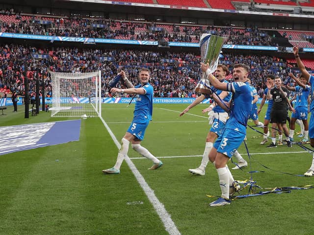 Harrison Burrows lifts the trophy in front of the adoring Posh fans. Photo: Joe Dent.