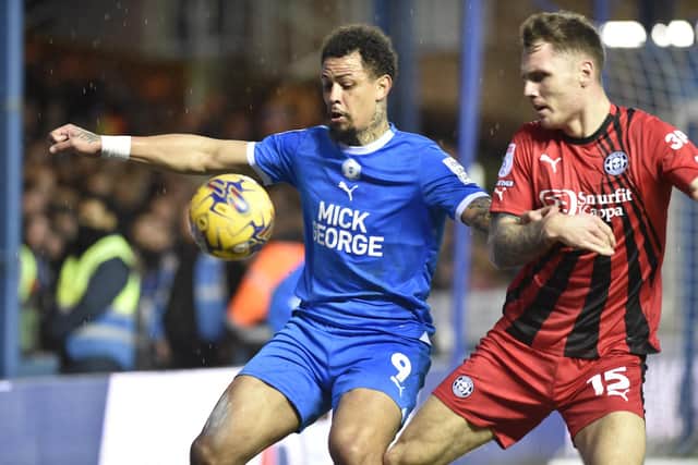 Jonson Clarke-Harris hols off Wigan's Jason Kerr in February. Photo: David Lowndes.