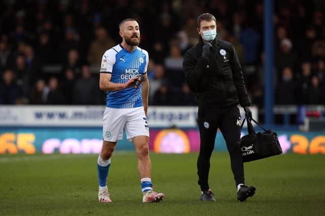 Dan Butler limps off in the Championship match against Millwall. Photo: Joe Dent/theposh.com.