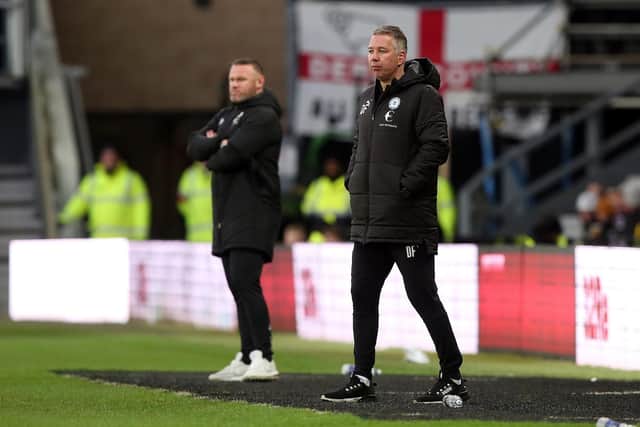 Rival managers Wayne Rooney (left) and Darren Ferguson watch Derby beat Posh at Pride Park last season. Photo: Joe Dent/theposh.com