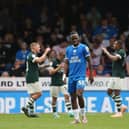 Peter Kioso of Peterborough United looks dejected as Derby County players celebrate scoring. Photo: Joe Dent.