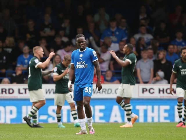 Peter Kioso of Peterborough United looks dejected as Derby County players celebrate scoring. Photo: Joe Dent.
