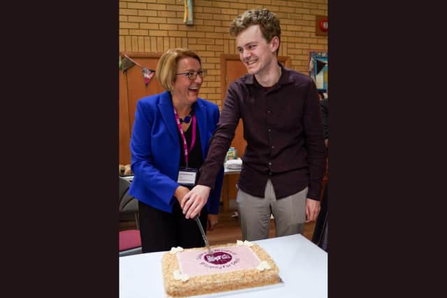 TLM Shop chief exec Amanda Norman cuts the cake with MP Sam Carling.