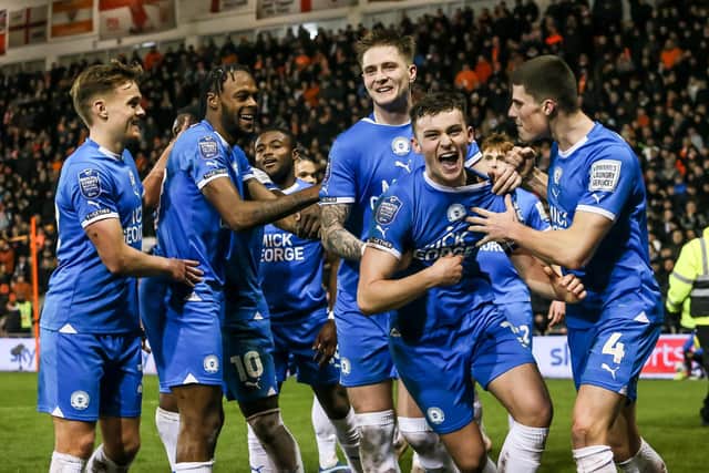 Harrison Burrows (second right) and Ricky-Jade Jones (second left) in the middle of Posh celebrations at Blackpool. Photo Joe Dent/theposh.com.