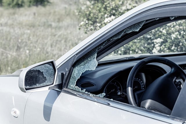 Thieves smashed a window of a car and glass was scattered throughout and belongings were stolen.