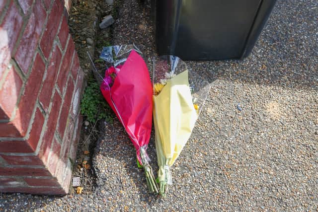 Police and floral tributes at and address in The Row, in Sutton, Cambs, following a double shooting in the county.