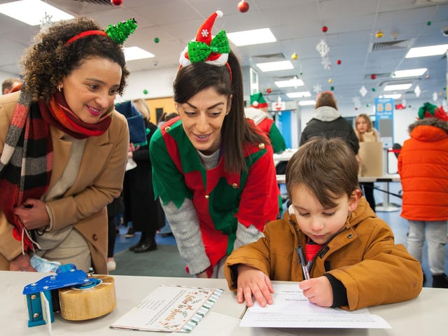 Amazon employees and their families helping to wrap presents for the children of Embrace Child Victims of Crime