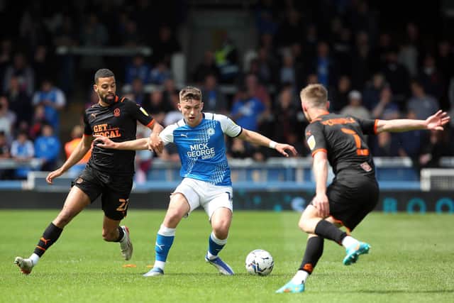 Harrison Burrows of Peterborough United in action with CJ Hamilton of Blackpool. Photo: Joe Dent.