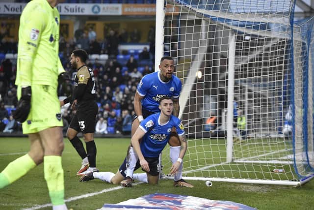 Posh captain Jonson Clarke-Harris picks Jack Taylor up after a missed chance against Portsmouth. Photo: David Lowndes.