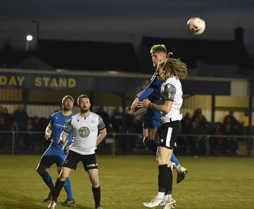 Sports midfielder Connor Kennedy (blue) challenges for a header in the game against Scarborough. Photo: David Lowndes.