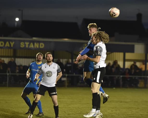 Sports midfielder Connor Kennedy (blue) challenges for a header in the game against Scarborough. Photo: David Lowndes.