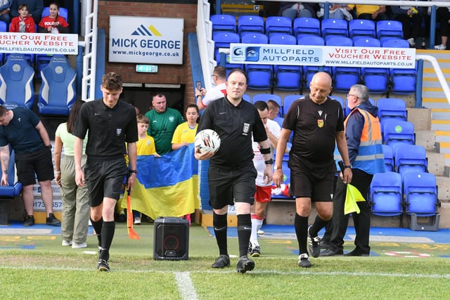 The referees take to the field.