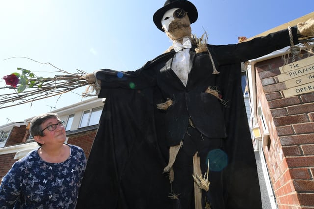 Susan Parry admiring the Phantom of the Opera scarecrow.