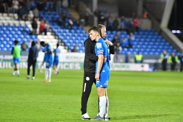 Peterborough United boss Darren Ferguson and club captain Harrison Burrows console each other at full time. Photo: David Lowndes.