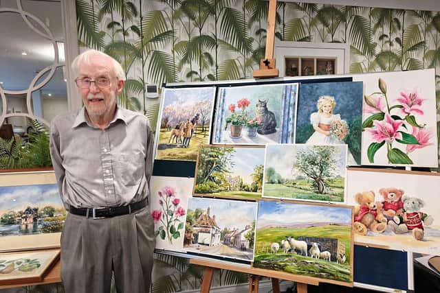 Frank Routley with some of his wife's paintings