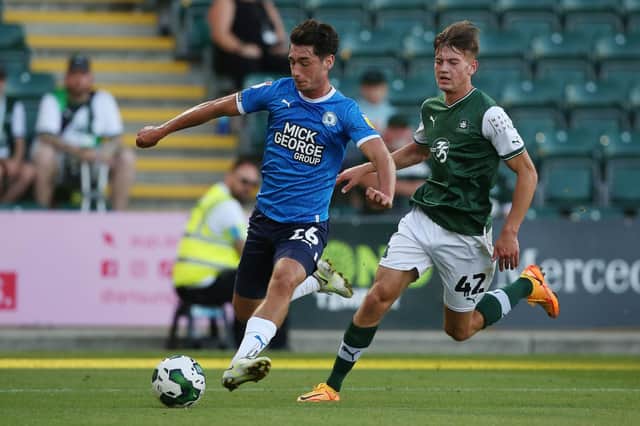 Joel Randall of Peterborough United in action with Jack Endacott of Plymouth Argyle. Photo: Joe Dent.