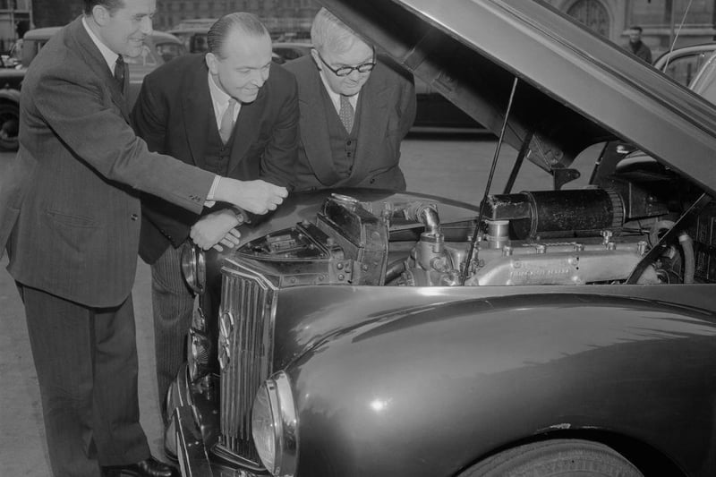 Harmar Nicholls (1912 - 2000, left), a former MP for Peterborough, demonstrates his diesel-engine saloon car to George Edward Peter Thorneycroft (centre), President of the Board of Trade, and Charles Hill (1904 - 1989, right), Parliamentary Secretary to the Ministry of Food.