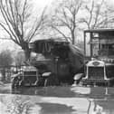 Stranded lorry drivers (left) look on as a bus ploughs through some serious floodwaters in Stanground to makes its way over The Lode on South Street (Peterborough Images Archive)