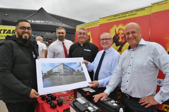 Kyam Damani, Alan Cakebread and Michael Davis show a new image of Millfield Autos' new premises at Bourges View, Peterborough, to Kevin Roberts and Lee Quinney from Banner Power Company during celebrations to mark the first anniversary of the opening of Millfield Autos' depot in Market Deeping.