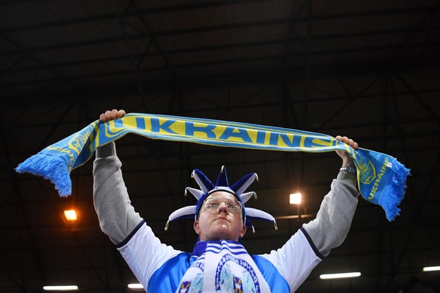 A Peterborough United fan holds a Ukrainian scarf to indicate peace and sympathy with Ukraine prior to the Emirates FA Cup Fifth Round match between Peterborough United and Manchester City.